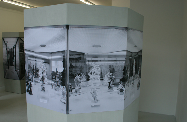 Alexandra Leykauf - Vitrine 4 (8-hoek) - 8 zijden van 57x198cm Hout en zwart-wit prints Alexandra Leykauf - Vitrine 4 (8-hoek) - 8 zijden van 57x198cm Hout en zwart-wit prints