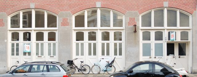 In de galerie staan enkele speakers en wat drums. Zo af en toe klinken er wat geluiden uit de boxen, soms resoneren de snaren op een trommel mee. De geluiden [&hellip;]