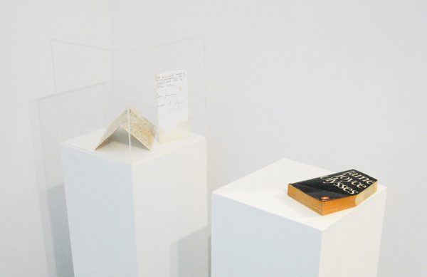 Dora Garcia - 12 attempts to forge a letter from Joyce to Ibsen - 5maal 20x21cm Inkt op in thee gedrenkt papier & Ulyses - 20x13x3cm Boeksnede (1986 editie van Ulysses van Joyce op sokkel)