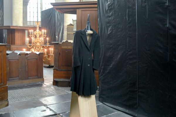 Christian Boltanski - Prende la Parole - Houten constructie, lamp, draad, donkere wollen jassen