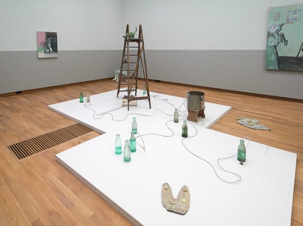 Arturo Kameya - Dinner is served - Houten ladder, glazen flessen, plastic slang, keramische kat, epoxy klei kat, houten kruk, tinnen pot, druppelpompen en vogelvormige bellen