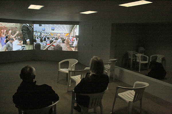 Aernout Mik - Tongues and Assistants - Tweekanaals videoinstallatie zonder geluid met live installatie